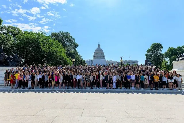 Hundreds of conference attendees gather for a group photo in front of the U.S. Capitol.